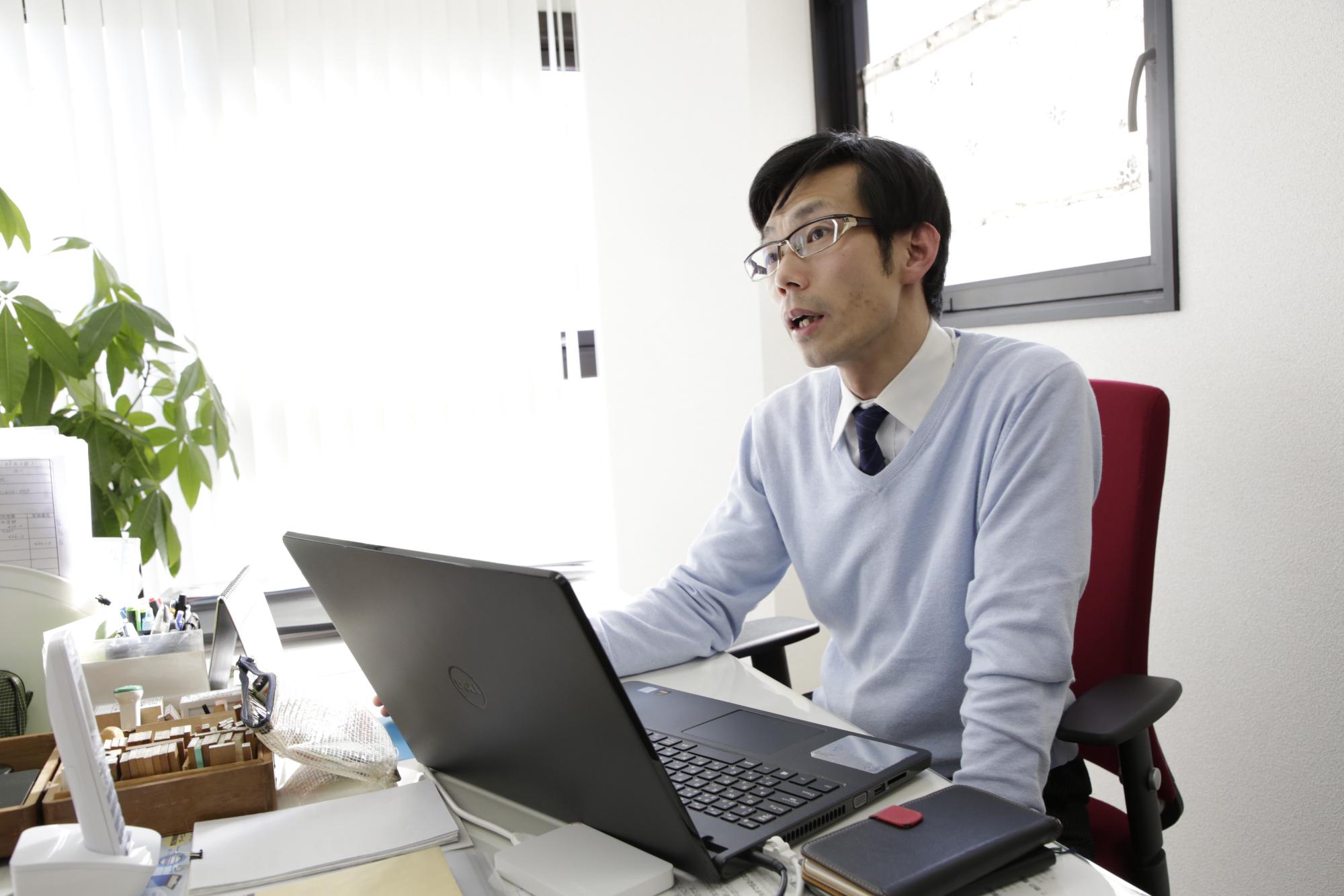 事務所のデスクで仕事をしている平井さんの様子を写した写真。