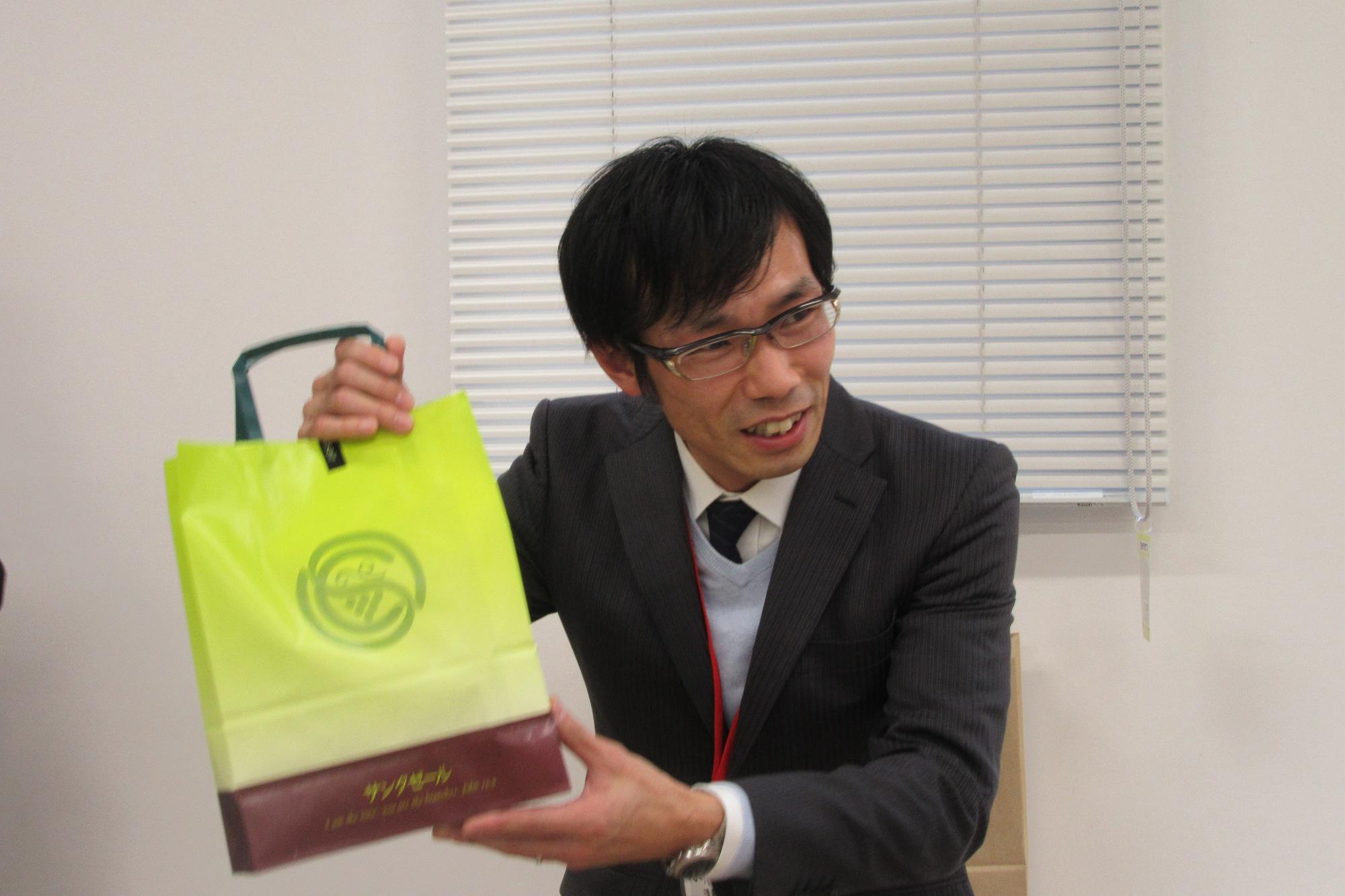 賞を獲得し商品を手にしている平井さんを写した写真。