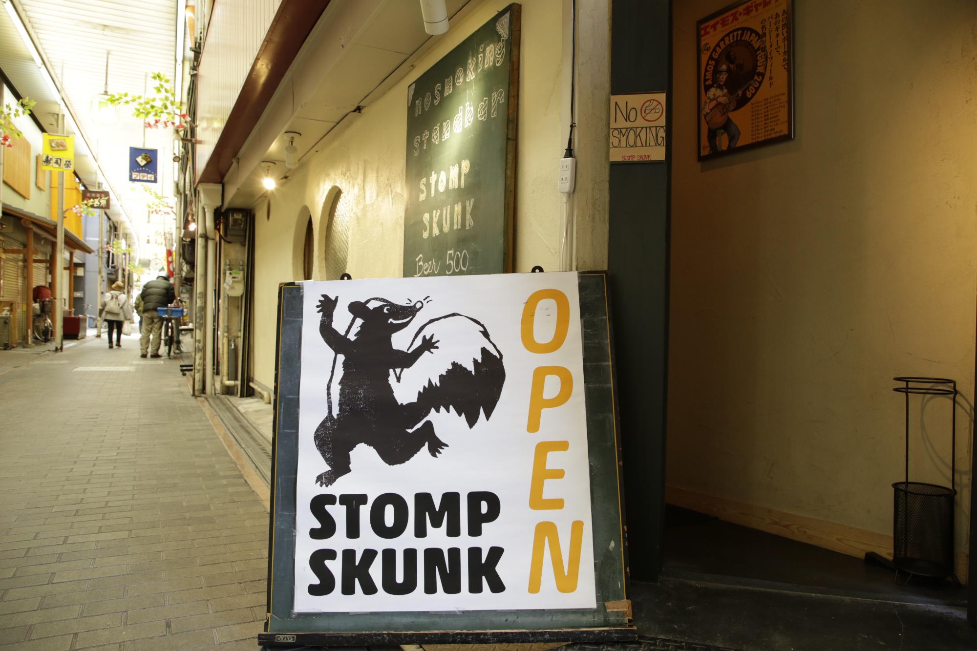 STOMP SKUNKの外観を写した写真。入口にはスカンクの絵が描かれた看板が立てかけられており、大きくオープンと書かれている。